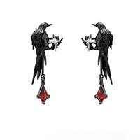 Thumbnail for A close-up image of a person's ear wearing a Gothic style ear cuff with a dangle crow design and red rhinestone details.