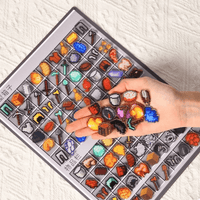 Thumbnail for Hand holding colorful miniature items above a tray with similar items on a textured surface