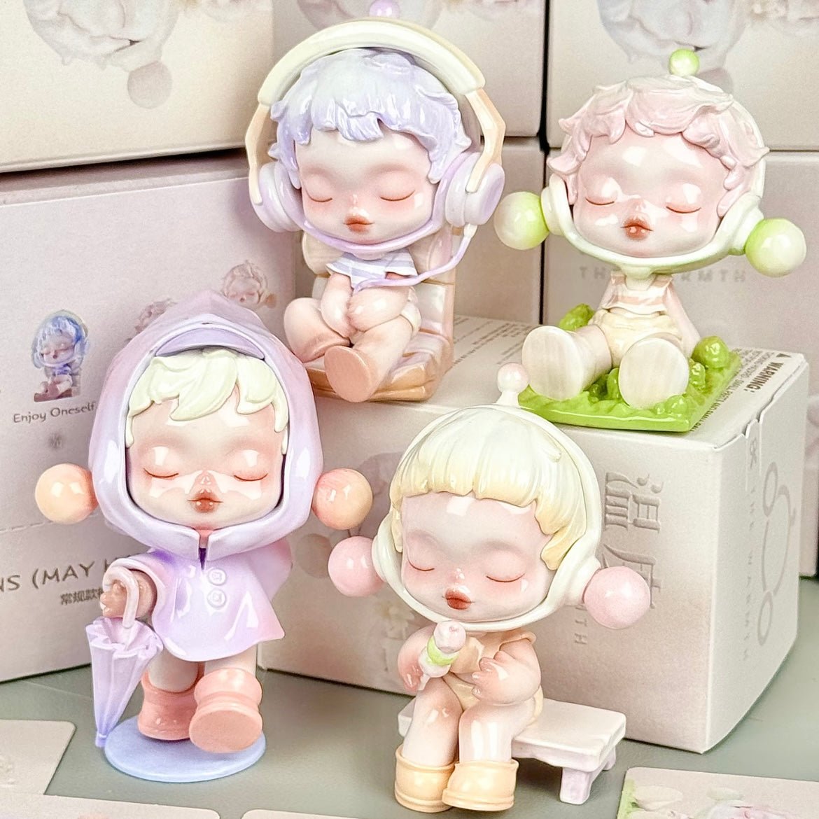 Set of four Pop Mart Skullpanda small figurines with different hairstyles and outfits on a light background.